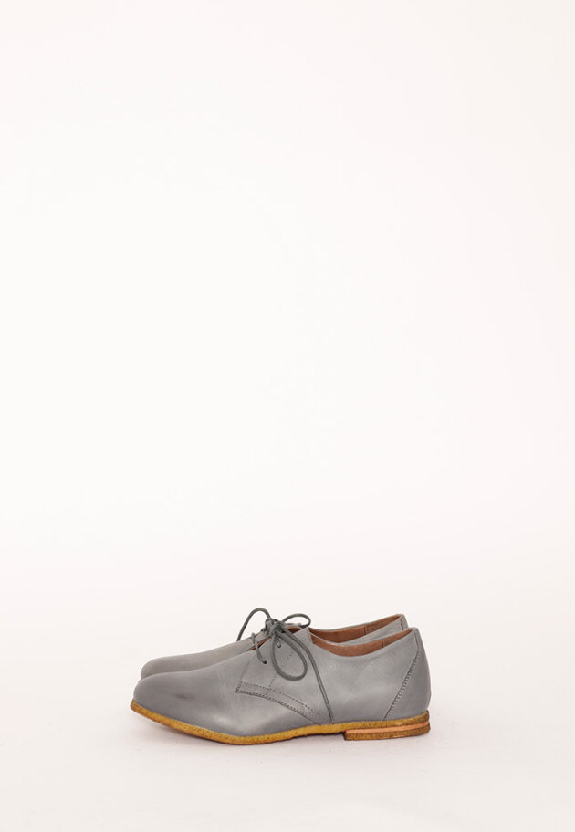 Low shoe with shoelace and a raw rubber sole
