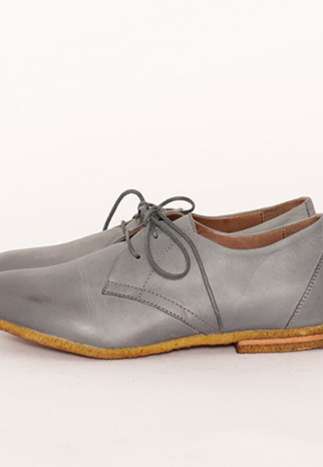 Low shoe with shoelace and a raw rubber sole
