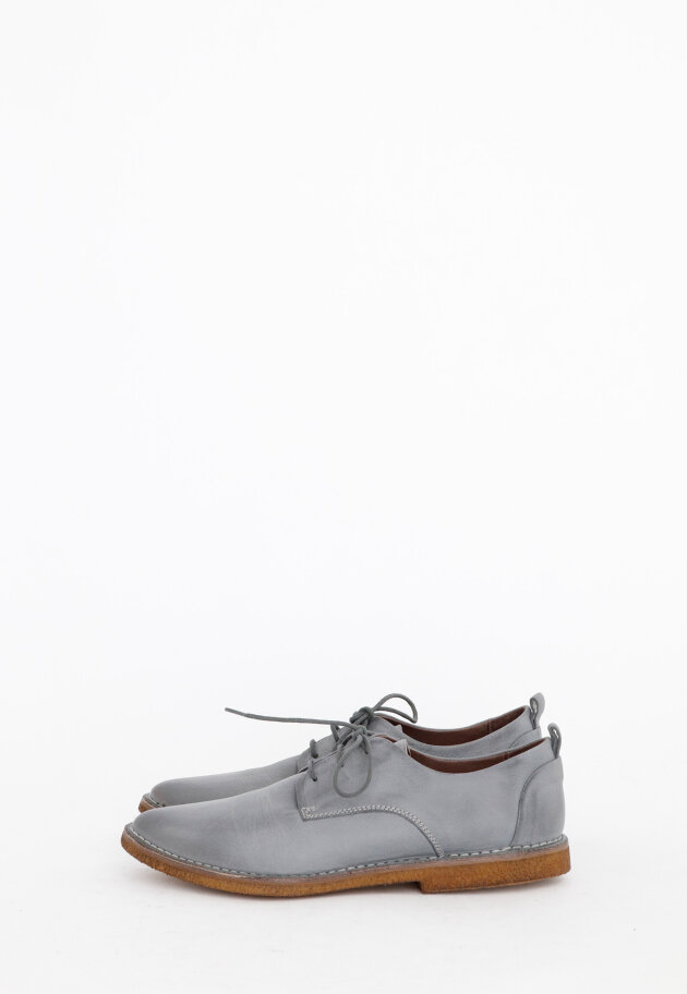 Shoe with shoelace and a raw rubber sole
