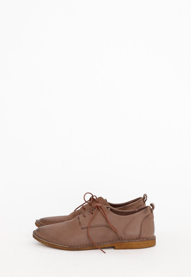 Shoe with shoelace and a raw rubber sole